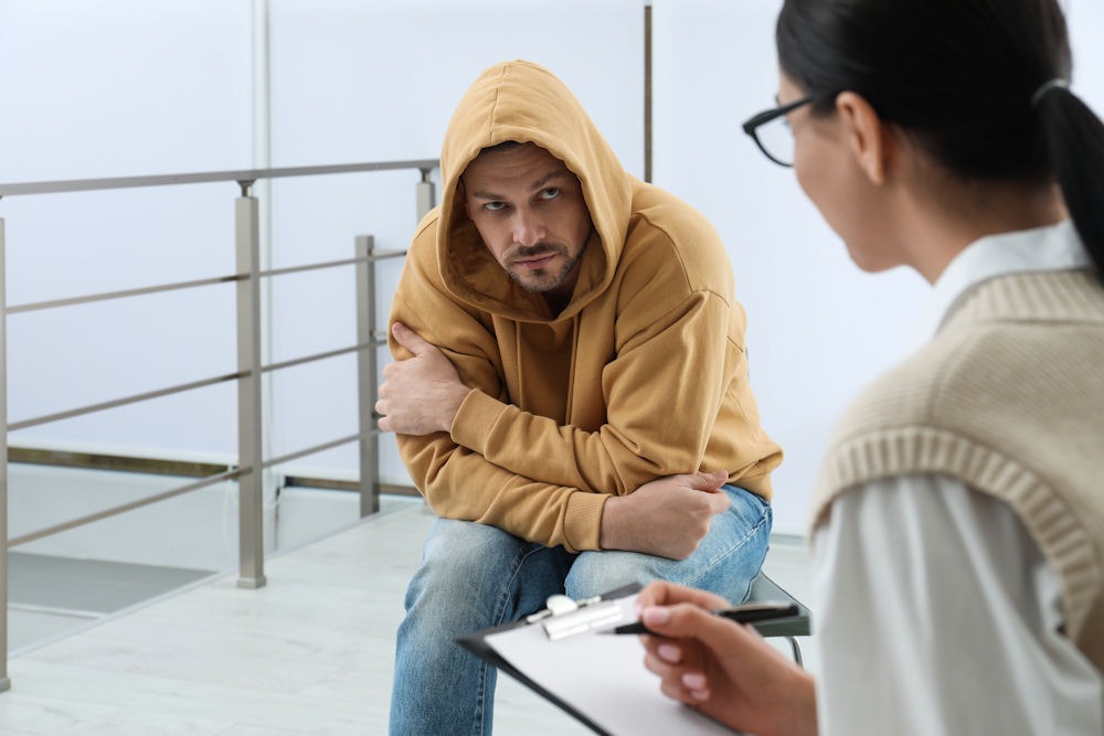 a man wearing a hoodie while attending individual therapy