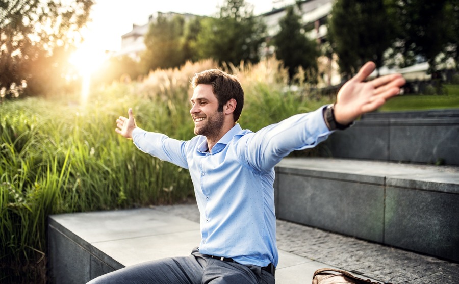 Man embracing positivity and freedom outdoors, symbolizing life after rehab