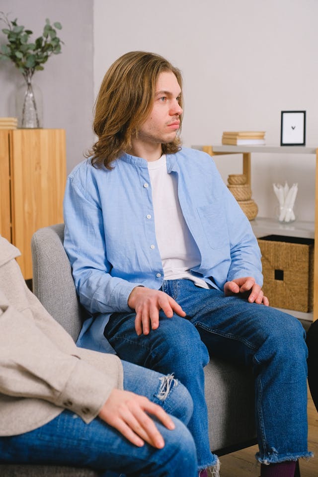 a man with opioid addiction sitting while listening to group discussion