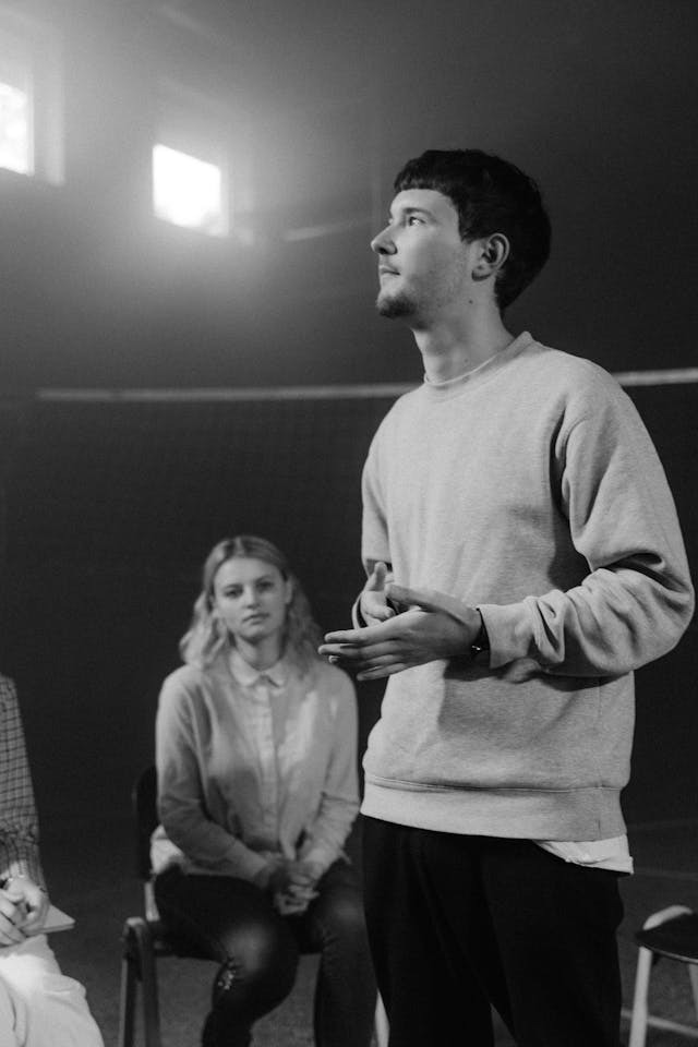 a man standing while talking in front of a group